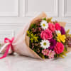 Mixed bouquet of pink, white, yellow, and purple flowers wrapped in paper