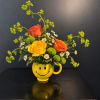 Yellow smiley-face mug holding roses and daisies