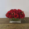 Red roses arranged in a clear modern vase