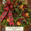 Christmas wreath with plaid bow, pinecones, oranges, and cinnamon sticks