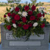 Red rose and white chrysanthemum arrangement on a gravestone