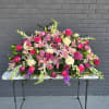 A sweeping casket spray designed for sympathy and memorial services, this large