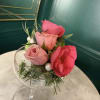 Three pink roses with green foliage and white pearl accents.
