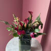 A striking, vertical composition featuring deep magenta calla lilies, purple and pink