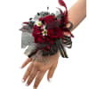 Deep red roses and ruffled red carnations form a dramatic focal point