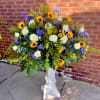 A burst of sunshine and quiet reverence, this flower arrangement pairs bold
