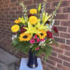 Bursting with sunny yellow lilies and bold sunflowers, this vibrant bouquet is