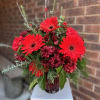 Bright red gerbera daisies take center stage in this celebratory flower arrangement