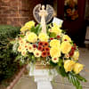 Sunny yellow roses clustered with cream daisy-like chrysanthemums and deep red accents