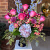 Vivid hot-pink roses take center stage in this celebratory flower arrangement, paired