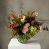 Mixed floral arrangement in a clear glass vase with pink and cream blooms