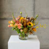Mixed bouquet in a clear glass vase with sunflowers and peach roses