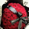 Impactante ramo de rosas rojas adornado con un papel de lujo Dior