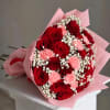 Bouquet of red roses and pink carnations wrapped in pink paper