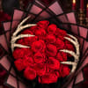 Bouquet of red roses wrapped with black paper and skeletal hands