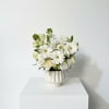 Soft roses, delicate lisianthus, and partially opened lilies fill the composition for