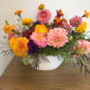 Colorful mixed flower arrangement in a white bowl vase