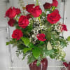 A cluster of a dozen deep red roses creates an immediate, romantic