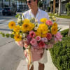 A burst of sunny yellow gerbera daisies and roses crowns this Wynwood