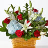 Basket arrangement of red roses, white lilies, and blue hydrangeas