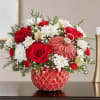 Red roses and white daisies in a red patterned vase with gold ornaments