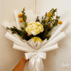 White and yellow bouquet with orange pom-pom flowers wrapped in white paper