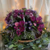 A luxurious cluster of purple chrysanthemums and lavender daisy-like asters makes a