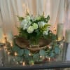 A dense cluster of white roses, hydrangeas, carnations and alstroemeria-softly accented with