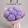 A soft and dreamy bouquet of lavender hydrangeas wrapped in blush pink