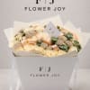 A luxury Flower Joy floral box filled with elegant cream-white roses, soft