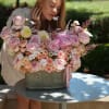 Large pink and cream rose arrangement in a gray container