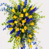 Bold yellow roses paired with vivid blue delphinium-style blooms give this standing