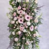 A gentle vertical spray of pastel blooms, this sympathy flower arrangement is