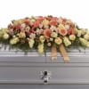 A soft cascade of pastel roses, gerbera daisies, and clustered blooms creates