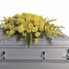 A luminous, all-yellow casket spray that brings warmth and uplifting presence to