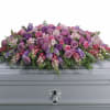 Soft lavender and pink roses center this casket spray, their romantic hues