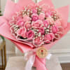 Pink rose bouquet wrapped in pink paper with a white ribbon