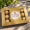 Box of Ferrero Rocher chocolates on a stone surface outdoors