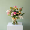 A cheerful garden-inspired arrangement featuring romantic roses, delicate spray roses, soft seasonal