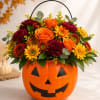 Halloween pumpkin container filled with orange and yellow flowers
