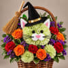 Basket arrangement with flowers styled as a cat wearing a witch hat