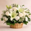 White lilies and roses arranged in a wicker basket
