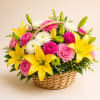 Basket arrangement of yellow lilies and pink and white carnations