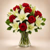 Red roses and white lilies arranged in a clear glass vase