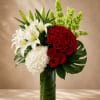 Red roses, white lilies, and white hydrangea in a tall glass vase