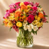 Mixed bouquet of roses and alstroemeria in a clear glass vase