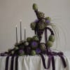 Artistic arrangement of artichokes with purple ribbon and candles