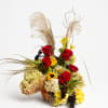 Autumn floral arrangement with red roses, yellow blooms, and dried grasses in a vase