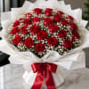 A dense dome of vivid red roses clustered with delicate white baby's