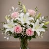 A calm, elegant mix of white lilies and soft pink roses arranged